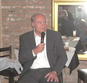 A man in suit and tie holding a microphone.