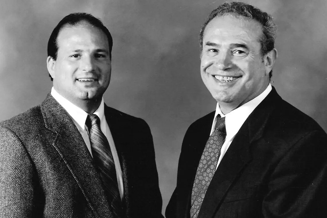 Two men in suits and ties standing next to each other.