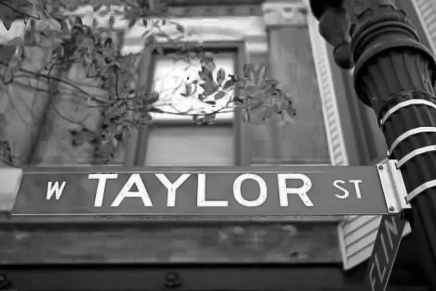 A black and white photo of the taylor street sign.