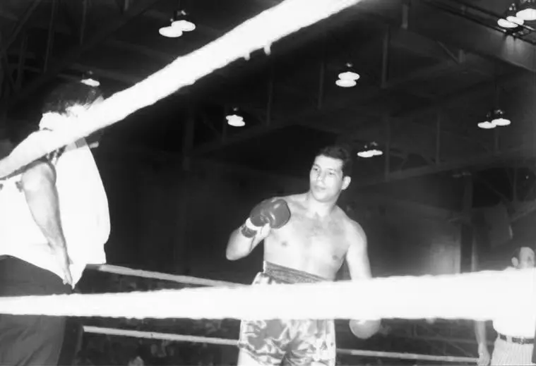 A man in the ring with his hands raised.