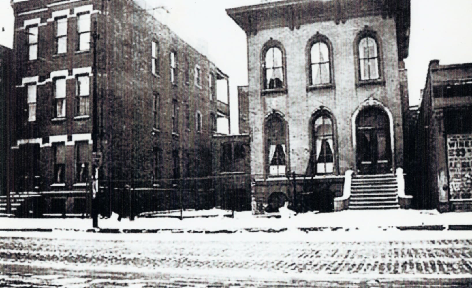 A black and white photo of two buildings in the snow.